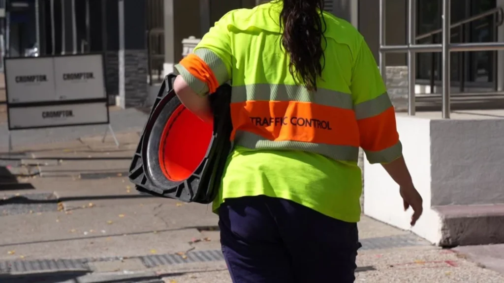 Traffic control worker carrying safety cones