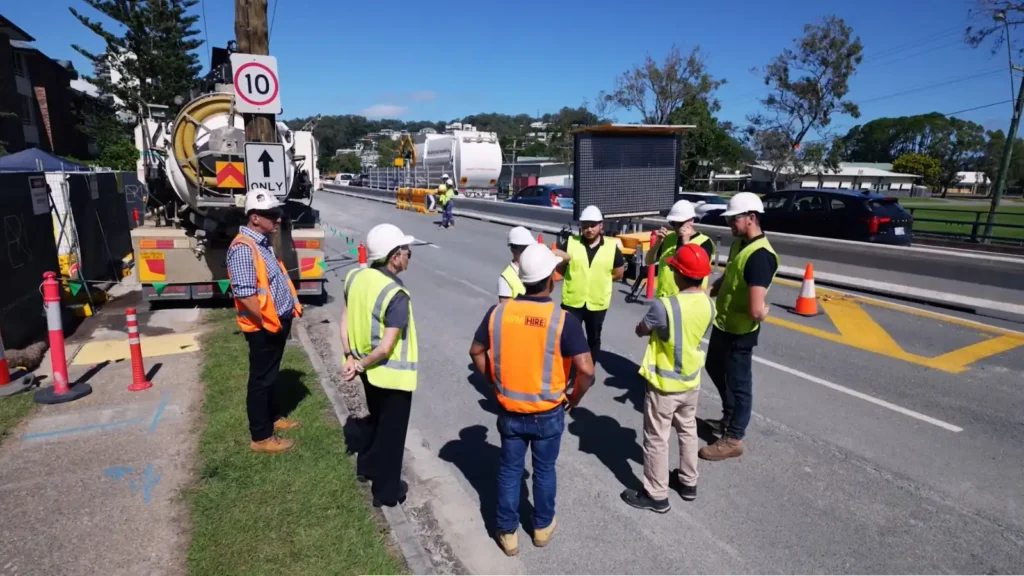 Traffic management team conducting roadside safety briefing during active roadwork operations