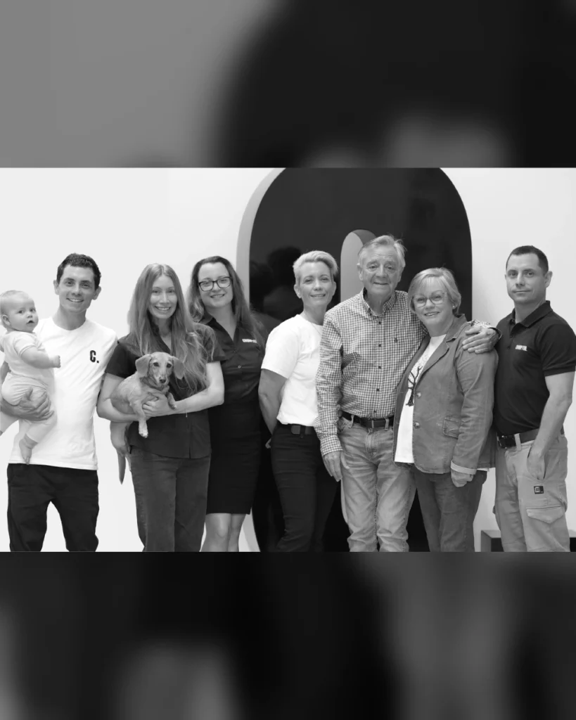 Crompton family and team members posing together with a dog for a group portrait