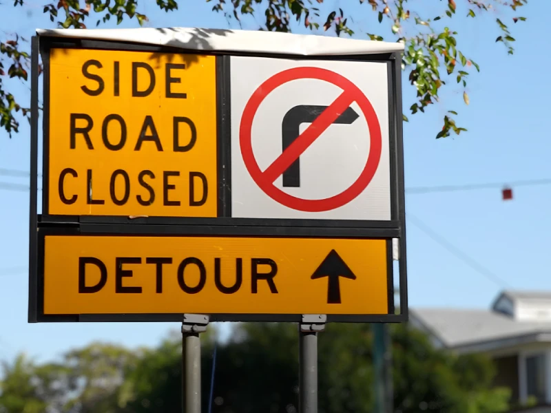 Permanent traffic control sign providing road closure and detour directions