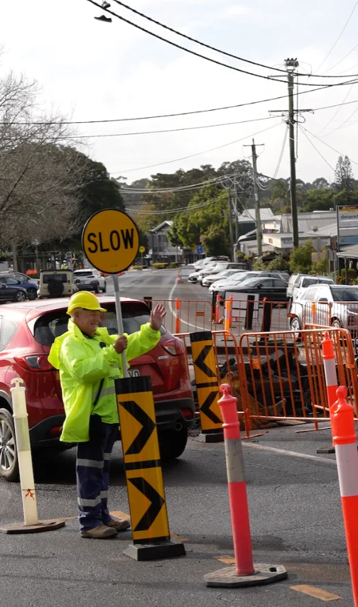 Traffic controller managing roadwork with temporary traffic signs and barriers